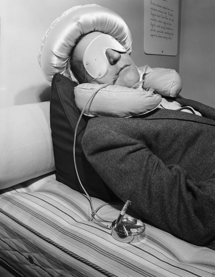 American Entertainer Garry Moore Trying Out A Special Contraption For Smoking To Forestall Burning Bedclothes Should He Fall Asleep With The Cigarette Still Lit, 1953