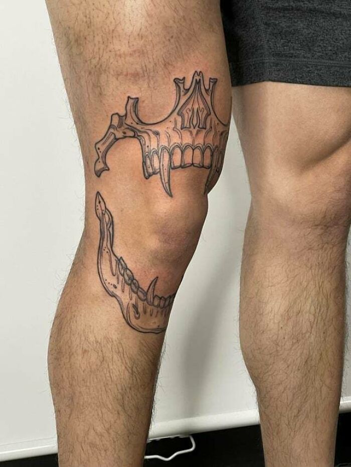 Knee tattoo featuring a detailed jawbone design on a person's leg, emphasizing unique tattoo styles.