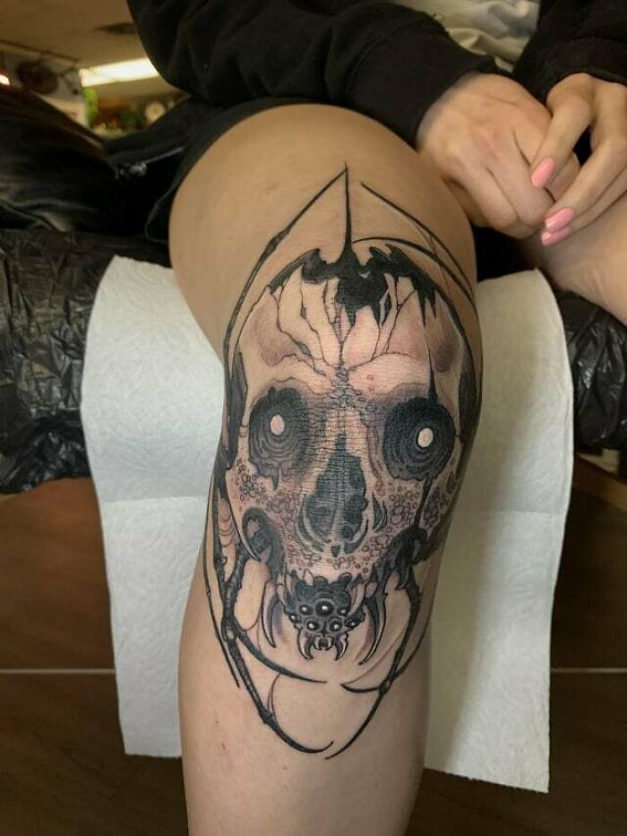 Detailed knee tattoo design featuring dark, intricate patterns with a bold artistic style.