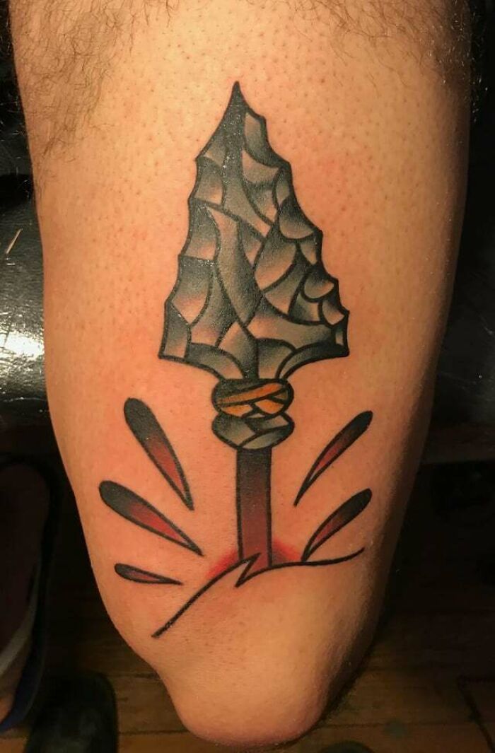 Abstract arrowhead knee tattoo design, bold and dynamic.