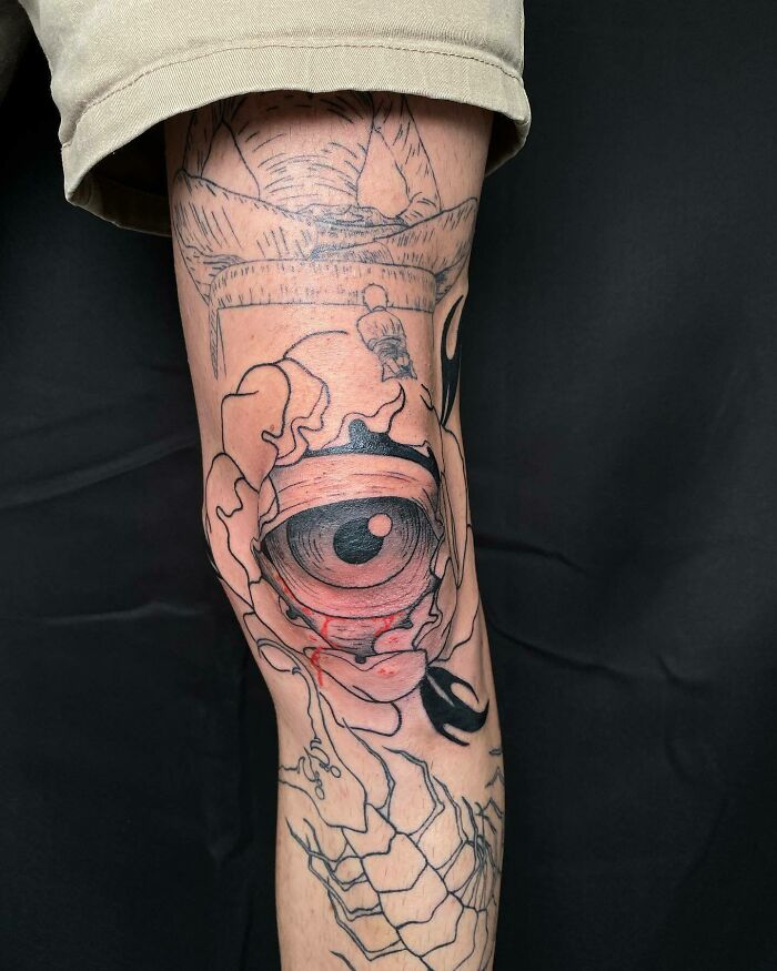 Abstract knee tattoo design featuring an eye, showcasing unique tattoo artistry.