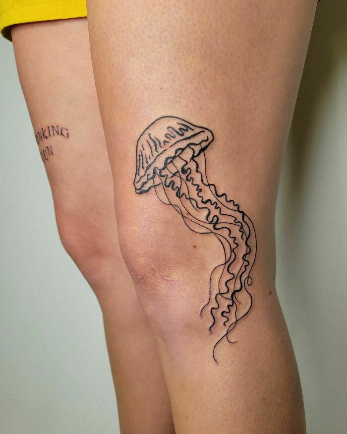 Jellyfish knee tattoo design on a person's leg, showcasing unique tattoo art style.