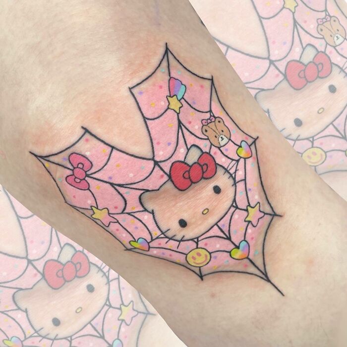 Hello Kitty knee tattoo with a colorful, playful web design.