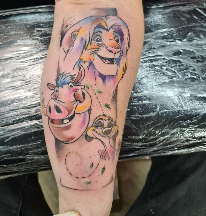 '90s tattoo of animated characters on arm, featuring vibrant colors and playful design.