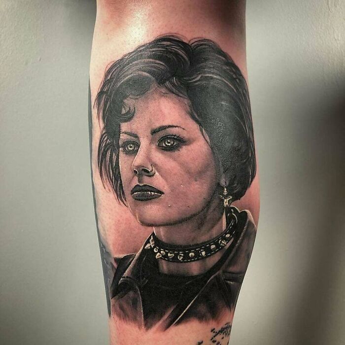 '90s tattoo featuring a realistic portrait of a punk woman with dark makeup and choker.