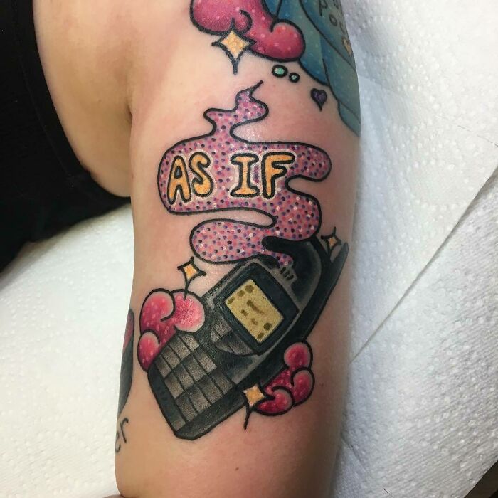 '90s tattoo featuring a vintage cell phone and "As If" text with colorful decorations.