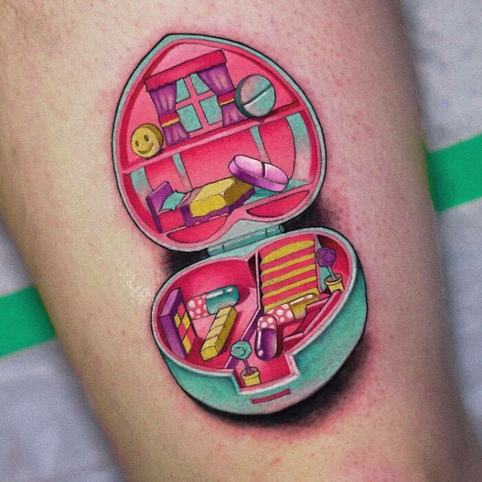 '90s culture tattoo featuring a colorful, detailed decorative compact design on skin.