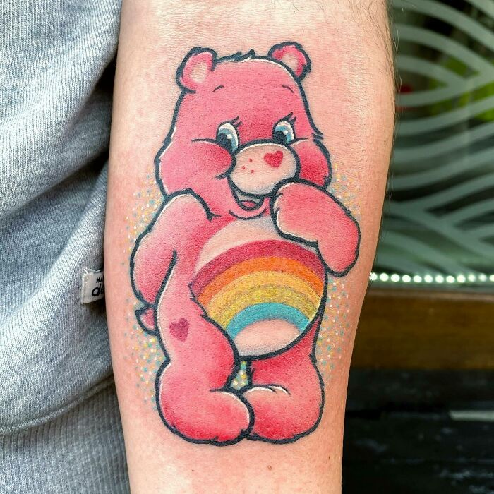 ‘90s tattoo of a pink bear with a rainbow on its belly, reflecting the decade's playful culture.
