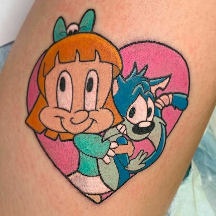 '90s cartoon tattoo with characters in a heart, highlighting nostalgic culture.