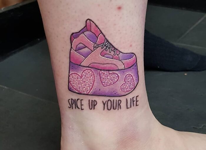 '90s tattoo of a colorful platform sneaker with "Spice Up Your Life" text on an ankle.
