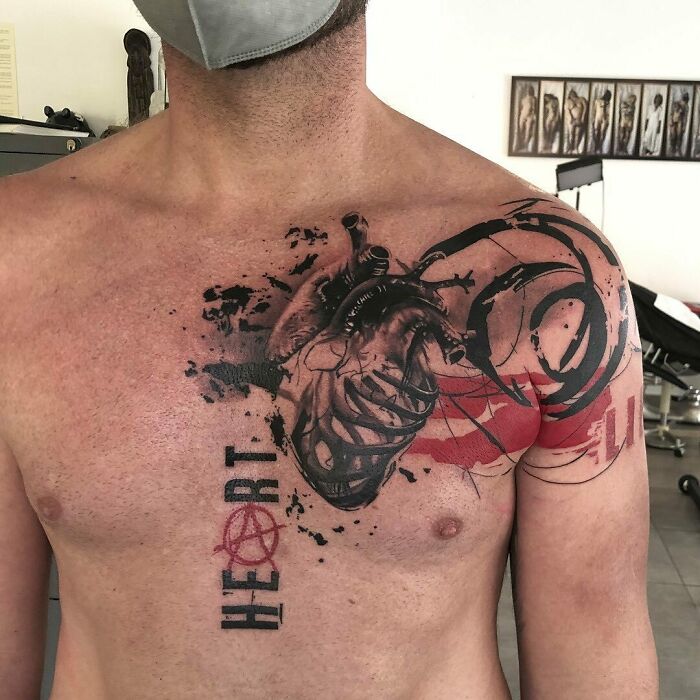 Chest with a Trash Polka tattoo design featuring a heart and abstract elements in black and red.