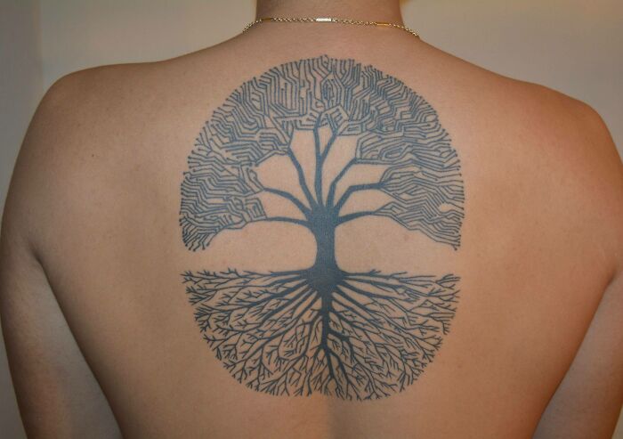 Tattoo of a majestic tree on a person's back, symbolizing the wonders of nature with intricate branches and roots.