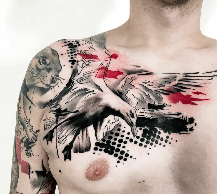 A detailed Trash Polka tattoo on a man's chest featuring a bird and abstract red and black elements.