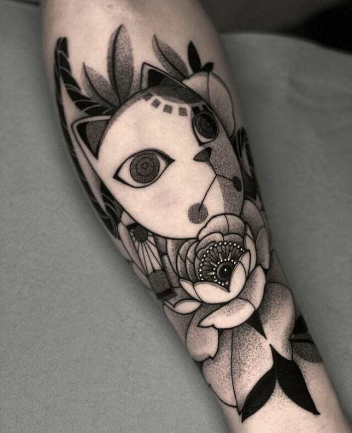 Anime tattoo of a geometric cat and flowers in black and gray ink, showcasing intricate linework and shading.
