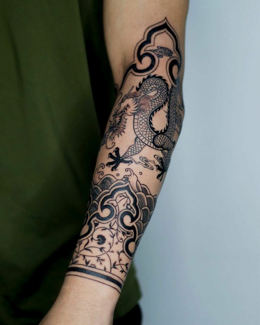 Intricate dragon tattoo design on forearm with detailed patterns and shading.