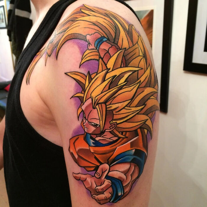 Anime tattoo on arm featuring a character with spiky hair and colorful outfit, showcasing cool design elements.