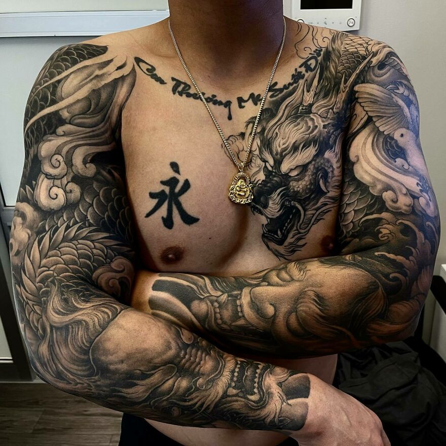 Tattooed arms and chest featuring intricate dragon designs, showcasing bold dragon tattoo art.