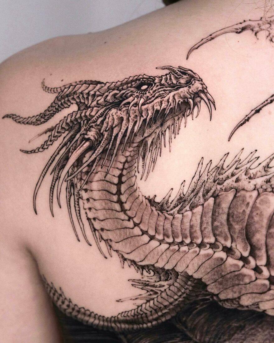 Detailed dragon tattoo design on back, showcasing intricate scales and fierce expression.