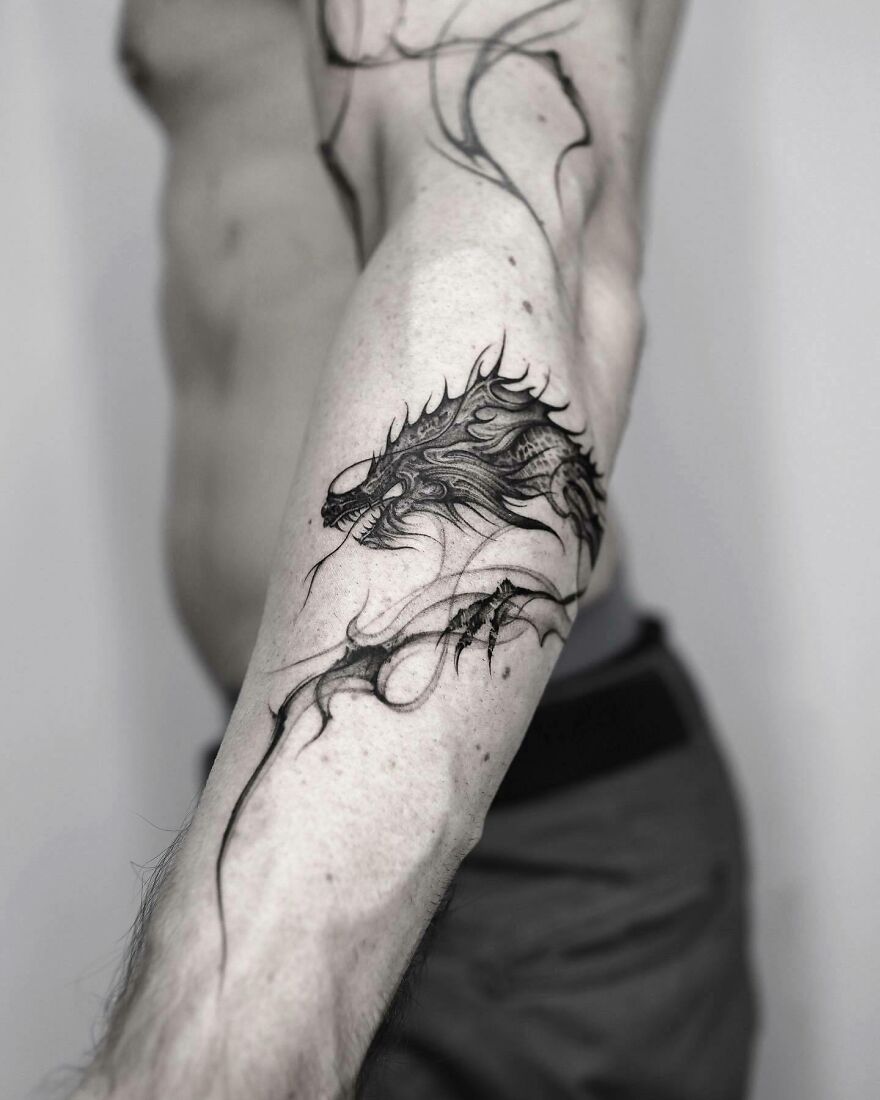 Dragon tattoo design on forearm, showcasing intricate details and fierce expression, perfect for inspiration.