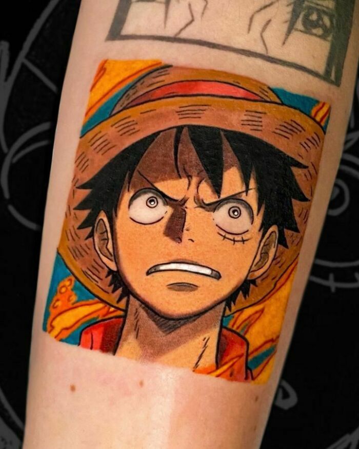 Colorful anime tattoo featuring a character with a straw hat, showcasing intricate design on forearm.