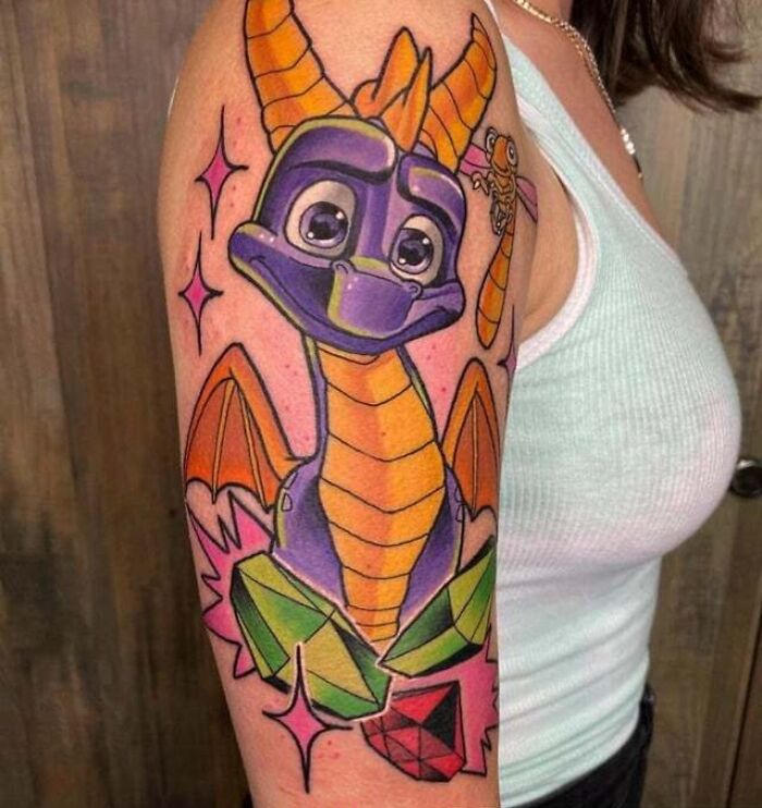 '90s tattoo of a colorful cartoon dragon on an arm, highlighting the decade's playful culture.