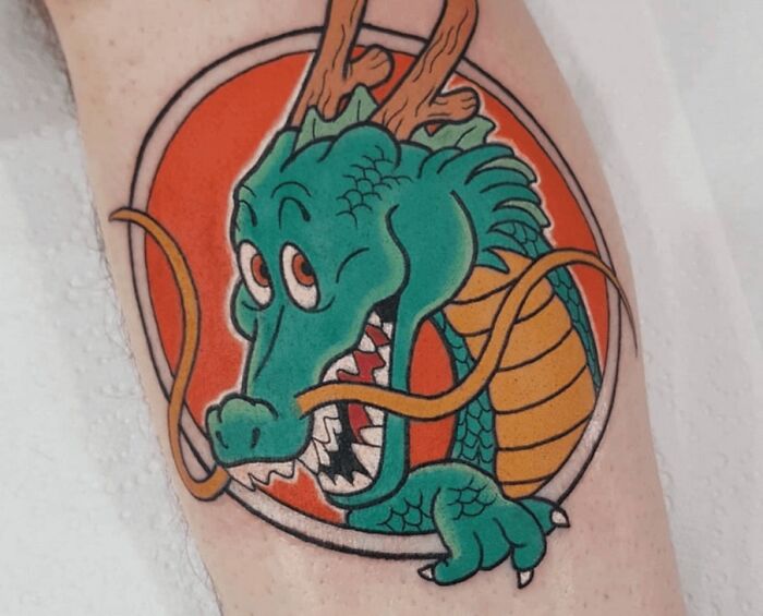 90s tattoo of a colorful dragon with orange background, showcasing decade's pop culture style.
