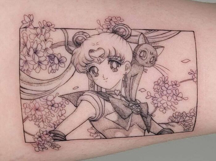 '90s tattoo featuring Sailor Moon and Luna, surrounded by flowers, reflecting iconic decade's culture.