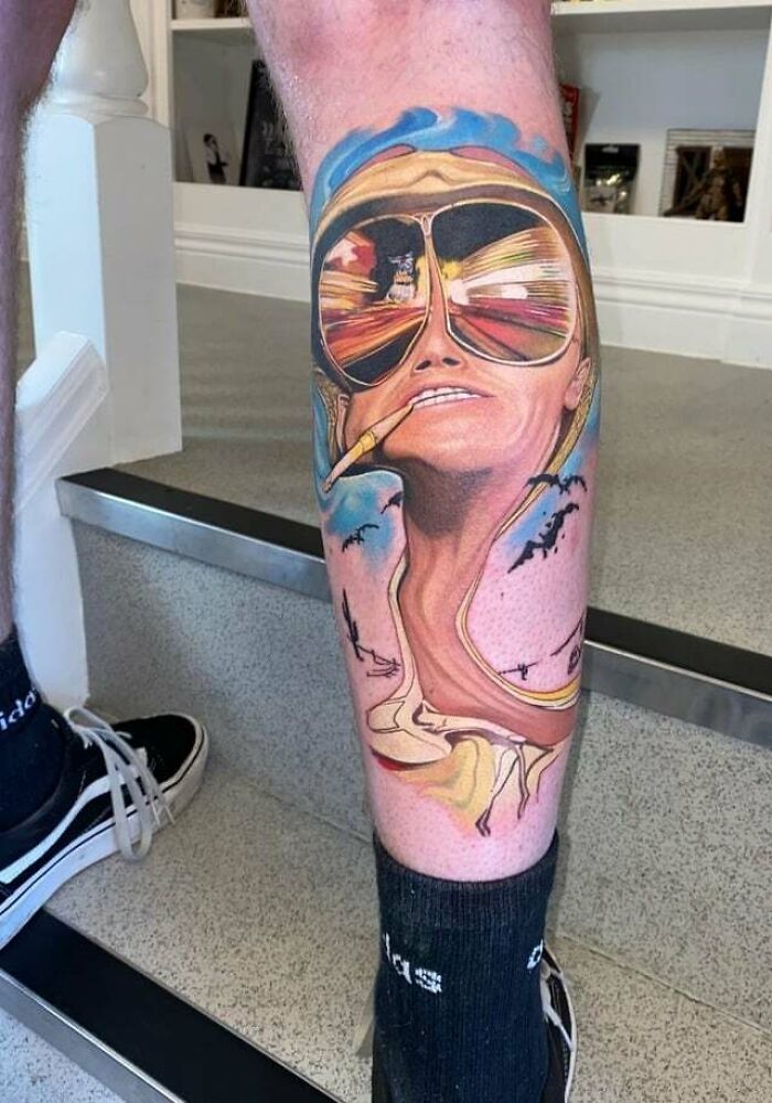 '90s tattoo featuring a psychedelic portrait with sunglasses and a cigarette, showcasing retro culture on a leg.
