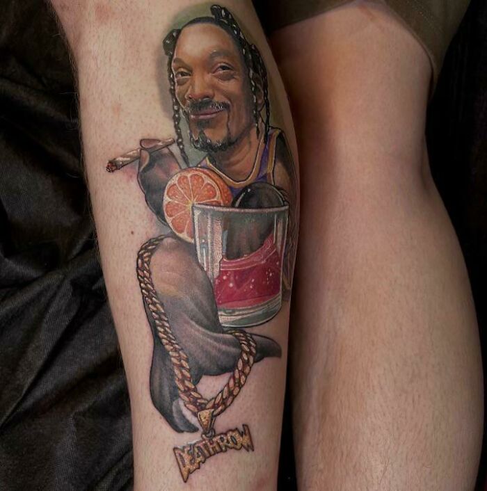 Tattoo of a '90s cultural icon with braids, drink, and chain, depicting nostalgic elements from the 1990s.