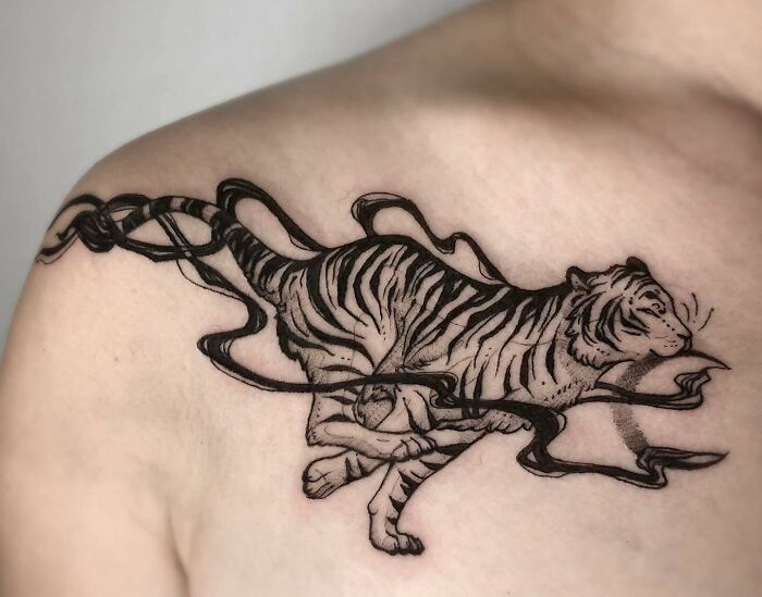 Tiger tattoo on a person's collarbone showcasing stunning body art design.