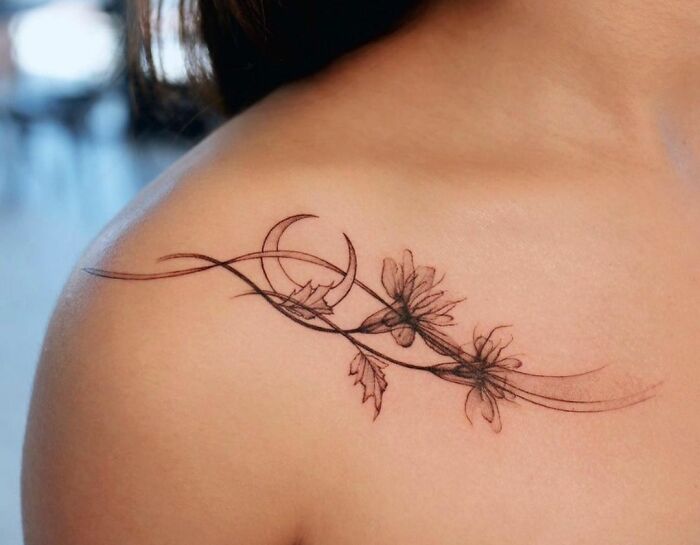 Floral collarbone tattoo design on skin, showcasing intricate lines and delicate flowers.
