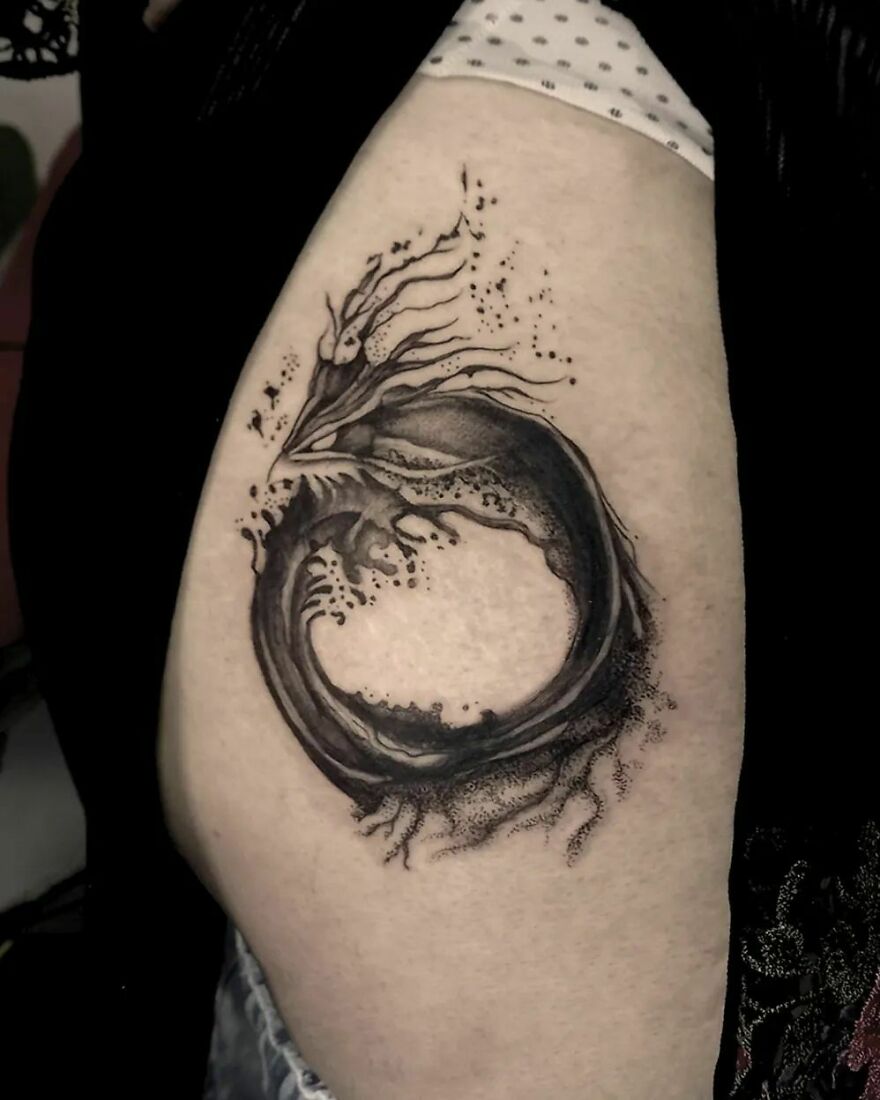 Abstract dragon tattoo design with swirling shapes on upper arm, highlighting unique dragon tattoo ideas.