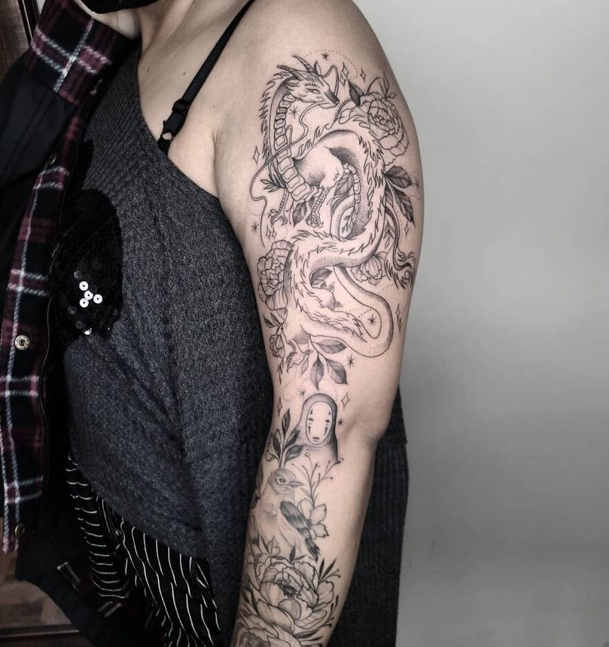 Dragon tattoo on a person's arm, featuring intricate details of flowers and mythical elements.