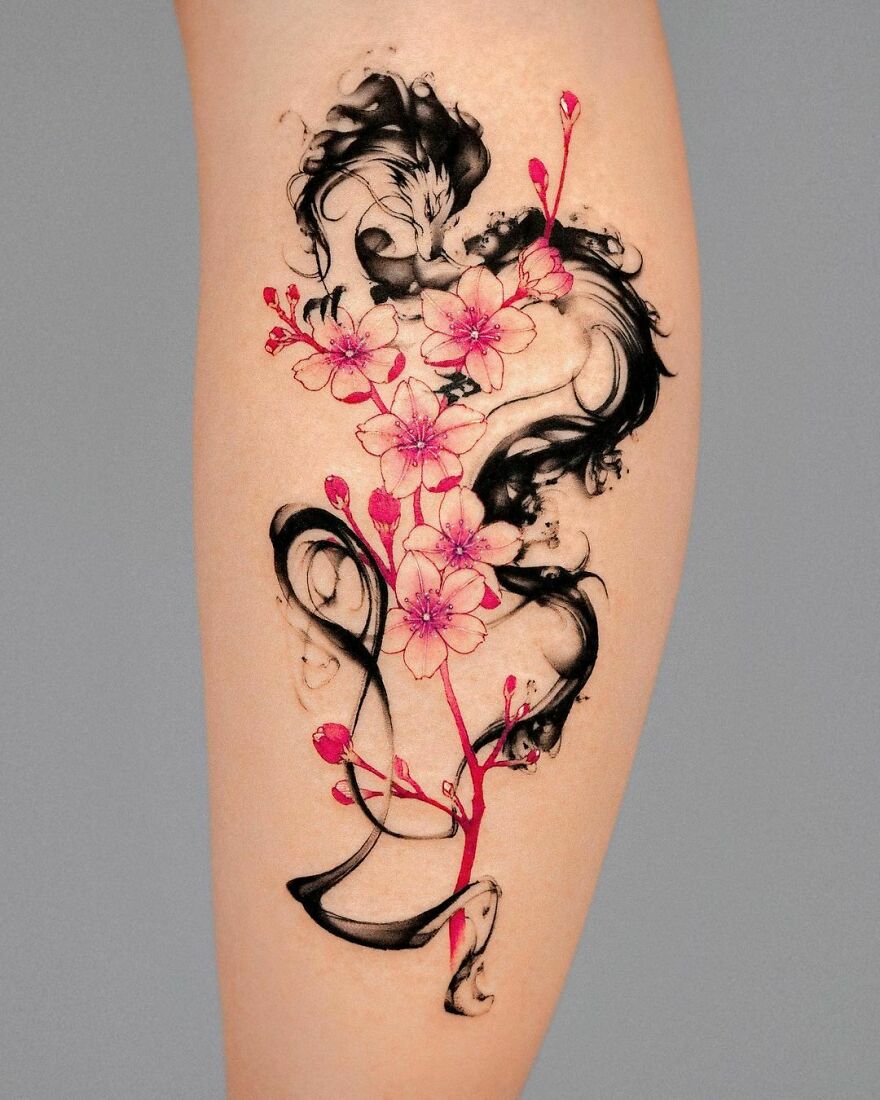 Dragon tattoo design with vibrant cherry blossoms on skin, blending elements of nature and mythology.