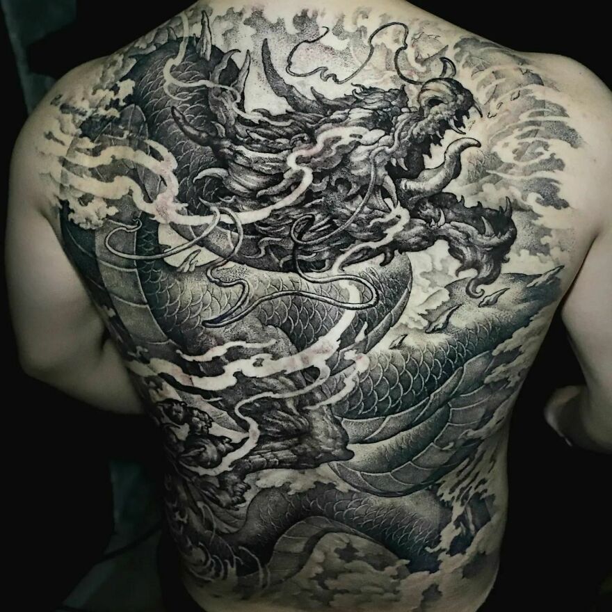 Back tattoo featuring an intricately detailed dragon design in black and gray tones.