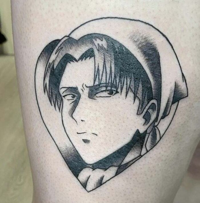 Anime tattoo featuring a serious character inside a heart shape, showcasing intricate shading and cool design.