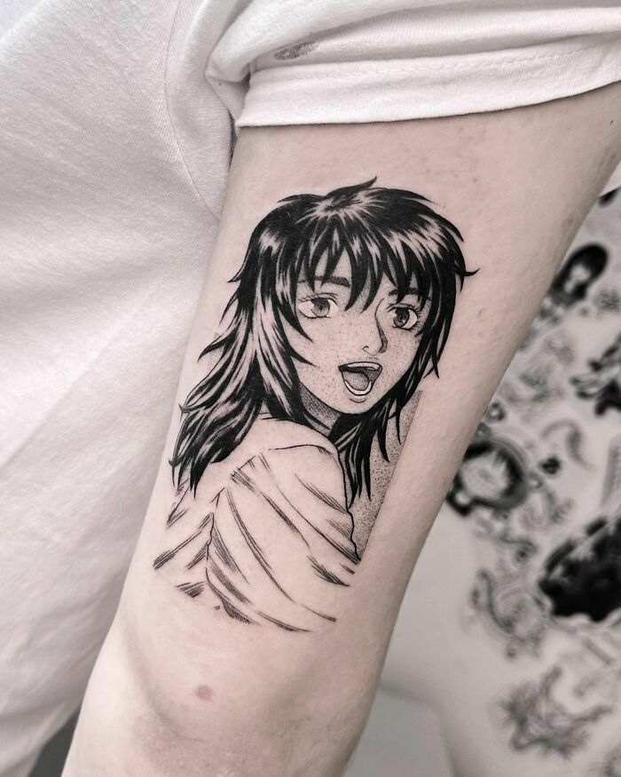 Anime tattoo of a character with long hair on someone's arm, showcasing detailed line work.