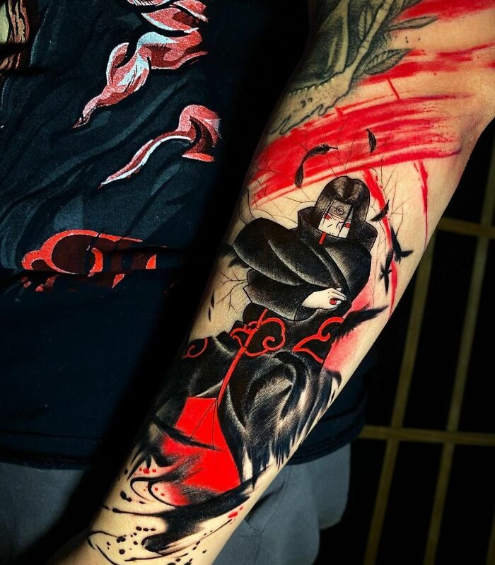 Arm with a detailed trash polka tattoo featuring red and black abstract designs and a hooded figure.