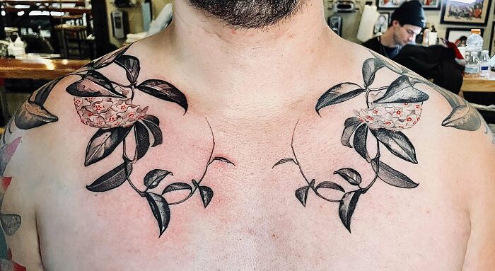 Floral collarbone tattoos on a person in a tattoo studio.