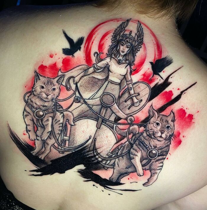 Trash Polka tattoo featuring a warrior goddess with cats on a vibrant red and black background.