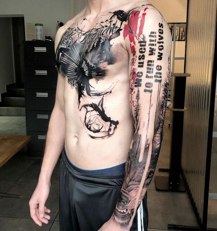 Man with a striking Trash Polka tattoo on arm and chest, featuring abstract designs and text.