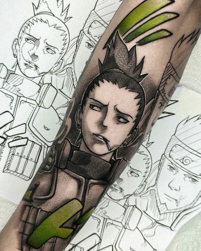 Anime tattoo design on forearm featuring a cool character with a serious expression and green accents.