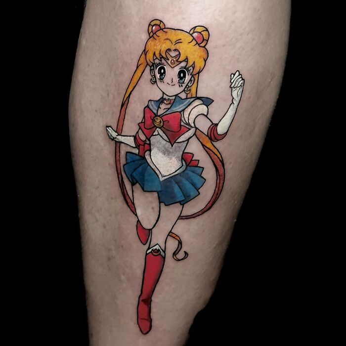 Anime tattoo of a sailor character on a leg, featuring vibrant colors and detailed design.