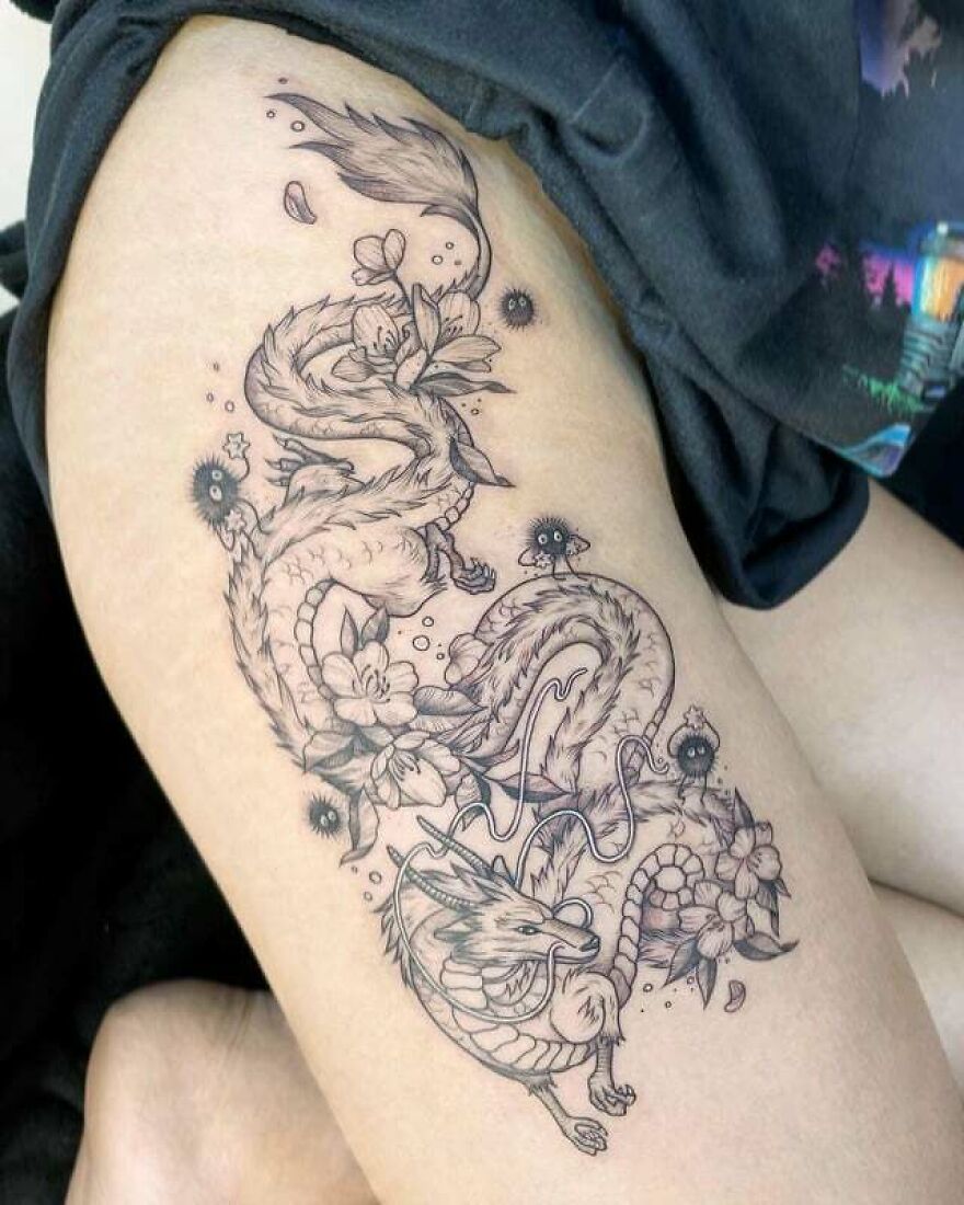 Intricate dragon tattoo design with floral details on skin.
