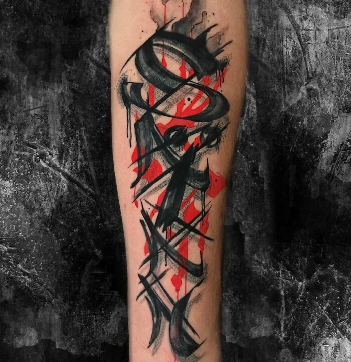 Trash Polka tattoo design in black and red on forearm, featuring abstract strokes and splashes.