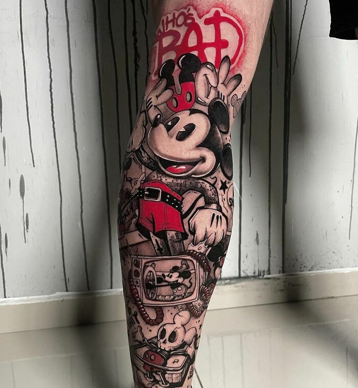 Trash Polka tattoo on leg featuring a bold cartoon character design with red accents.