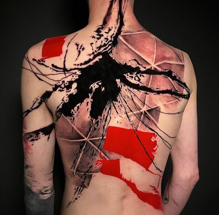 Back displaying an intricate Trash Polka tattoo design in black, red, and white abstract patterns.