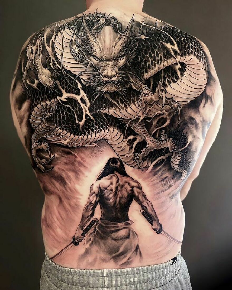 Back tattoo featuring a fierce dragon and a warrior, showcasing intricate dragon tattoo design.