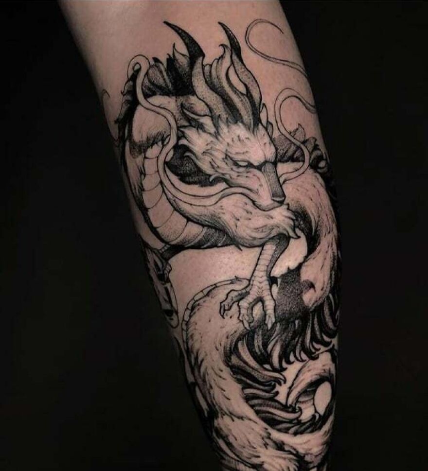 Black ink dragon tattoo swirling on forearm, showcasing intricate detail and artistry.