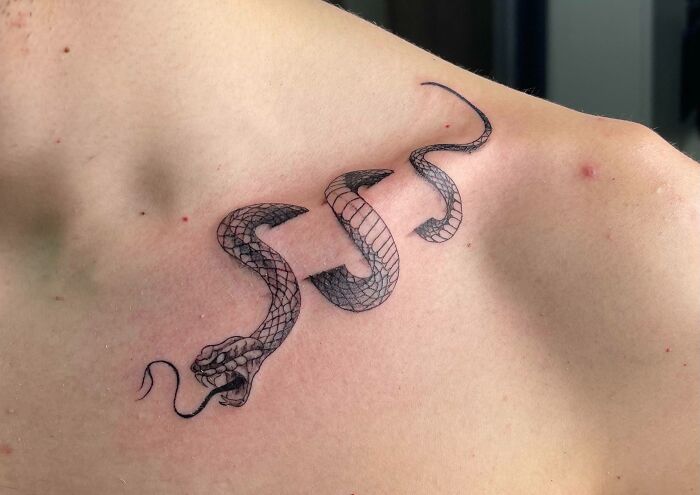 Snake tattoo design on a person's collarbone.